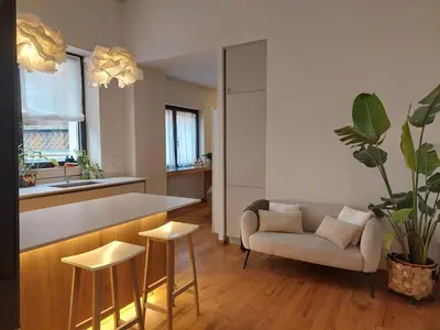a living room with a couch and a kitchen at Loft del Talvera 2 in Bolzano