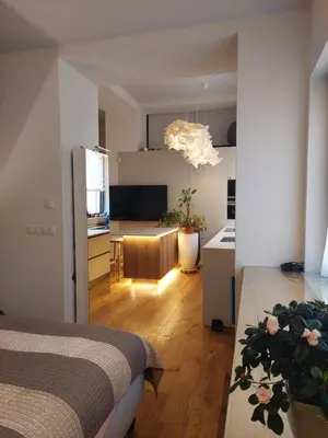 a room with a bed and a kitchen with a table at Loft del Talvera 2 in Bolzano