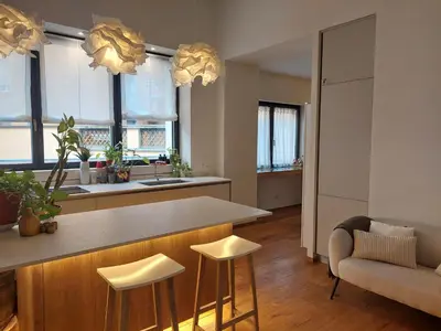 a kitchen with a bar with stools and a couch at Loft del Talvera 2 in Bolzano