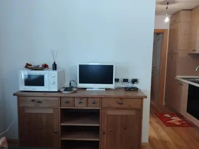 a desk with a microwave and a television on it at Villa Larici piano terra in Bellamonte
