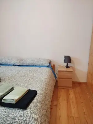 a bedroom with a bed and a lamp on a wooden floor at Villa Larici piano terra in Bellamonte