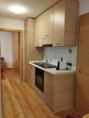 a kitchen with wooden cabinets and a sink at Villa Larici piano terra in Bellamonte
