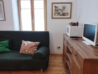 a living room with a couch and a television at Villa Larici piano terra in Bellamonte