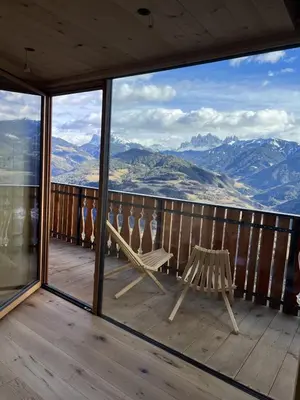 a balcony with a bench and a view of mountains at Proderhof in Feldthurns