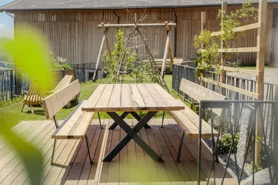a wooden table and benches on a deck at Proderhof in Feldthurns