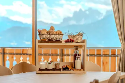 a table with a plate of bread and a bottle of milk at Proderhof in Feldthurns
