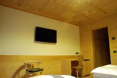 a room with a flat screen tv on a wall at Jägerhaus Agriturismo in Cortina dʼAmpezzo