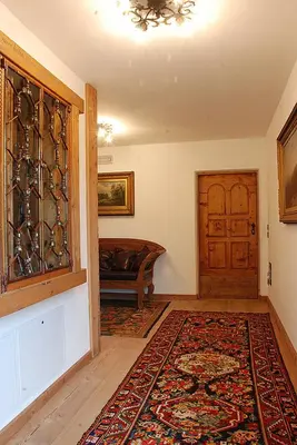 a living room with a door and a rug at Jägerhaus Agriturismo in Cortina dʼAmpezzo