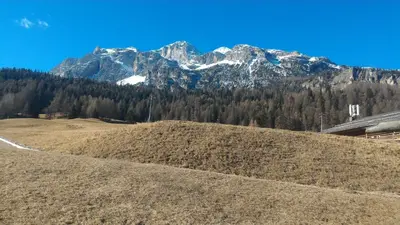 a large hill with a mountain in the background at Jägerhaus Agriturismo in Cortina dʼAmpezzo