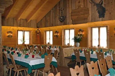 a dining room with tables and chairs in a barn at Jägerhaus Agriturismo in Cortina dʼAmpezzo