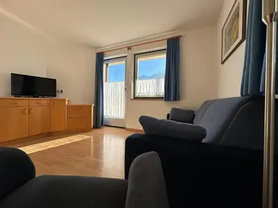 a living room with a couch and a tv at Appartments Anna in Valdaora di Sotto