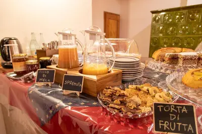 a table with a buffet of food and bread at Agritur Iellici in Castello di Fiemme