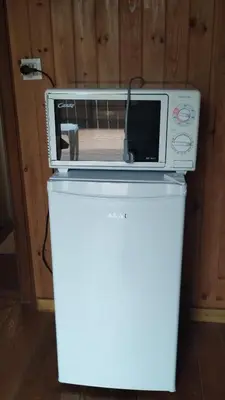 a microwave sitting on top of a white refrigerator at B&B SòT AL PIZ in Sagron Mis