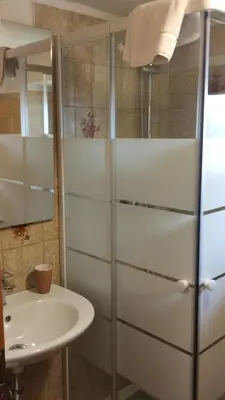 a bathroom with a sink and a refrigerator at B&B SòT AL PIZ in Sagron Mis
