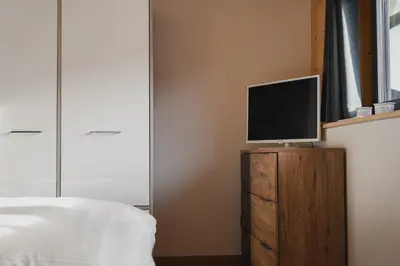 a bedroom with a bed and a tv on a dresser at MOUNTAIN DELUXE 27 APARTMENTS con WELLNESS in Cavalese