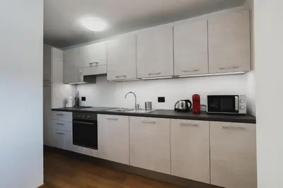 a kitchen with white cabinets and a sink and a microwave at MOUNTAIN DELUXE 27 APARTMENTS con WELLNESS in Cavalese