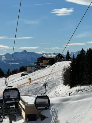 a ski lift with chairs on a snow covered slope at Verweilen auf Meran 2000 in Avelengo