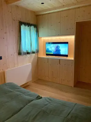a bedroom with a bed and a tv in a room at Verweilen auf Meran 2000 in Avelengo