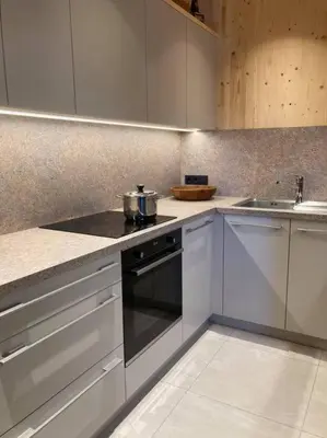 a kitchen with white cabinets and a stove and a sink at Verweilen auf Meran 2000 in Avelengo