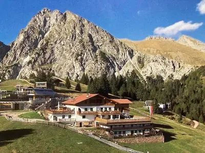 a large building in front of a mountain at Verweilen auf Meran 2000 in Avelengo
