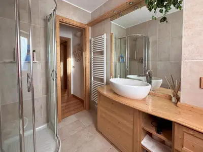 a bathroom with two sinks and a shower at Ciasa De Doni in Pozza di Fassa