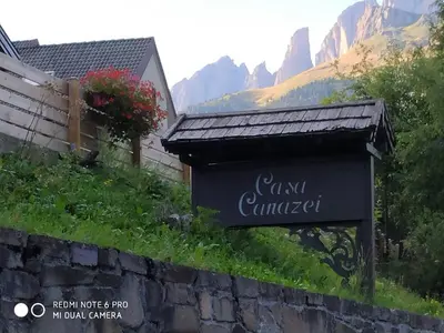 a sign at the entrance to a guest camp in the mountains at casa canazei in Alba di Canazei