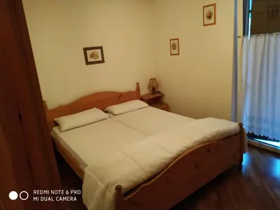 a bedroom with a wooden bed with two pillows on it at casa canazei in Alba di Canazei