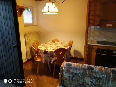a kitchen with a table and chairs in a room at casa canazei in Alba di Canazei