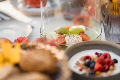 a table with a plate of food with fruit on it at Nikolausberg - Hof im Garten in Caldaro