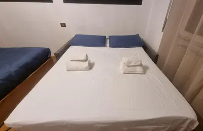a large white bed with two towels on it at Studio Apartment Ariston in centro a Cortina in Cortina dʼAmpezzo