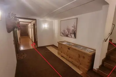 a living room with a wooden chest and stairs at Studio Apartment Ariston in centro a Cortina in Cortina dʼAmpezzo