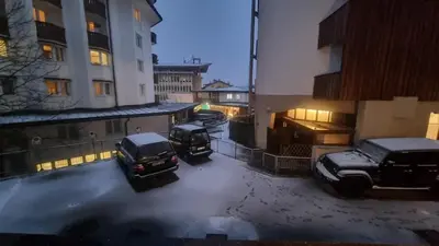 three cars parked in a parking lot in the snow at Studio Apartment Ariston in centro a Cortina in Cortina dʼAmpezzo