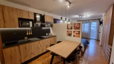 a kitchen with a wooden table in a room at Studio Apartment Ariston in centro a Cortina in Cortina dʼAmpezzo
