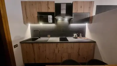 a kitchen with a sink and a microwave at Studio Apartment Ariston in centro a Cortina in Cortina dʼAmpezzo