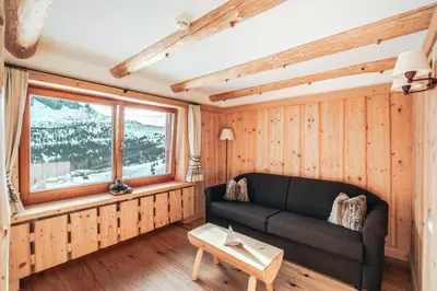 a living room with a couch and a window at Hotel Piz Seteur in Selva di Val Gardena