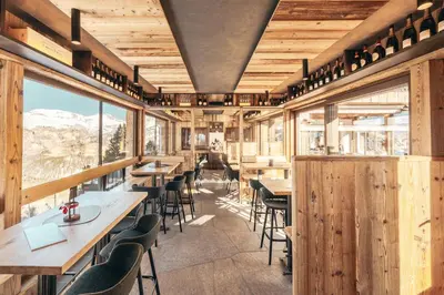 a restaurant with wooden walls and tables and chairs at Hotel Piz Seteur in Selva di Val Gardena