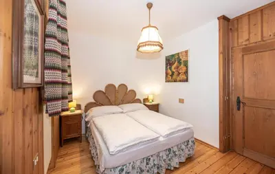 a bedroom with a bed with a wooden headboard at B&B Villa La Bercia in San Vigilio Di Marebbe