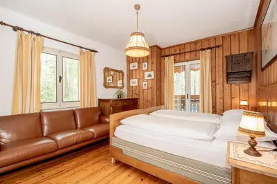 a bedroom with a large bed and a couch at B&B Villa La Bercia in San Vigilio Di Marebbe