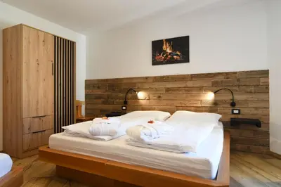 a bedroom with a bed with towels on it at Abete rosso in Tesero