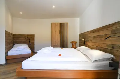 a bedroom with two beds and a wooden headboard at Abete rosso in Tesero
