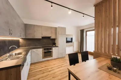 a living room with a couch and a kitchen at Oberhuberhof in Rodengo