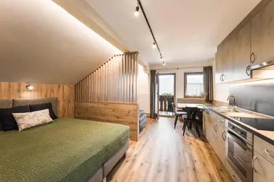 a bedroom with a bed and a kitchen with a sink at Oberhuberhof in Rodengo