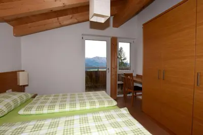 a bedroom with two beds and a table and a window at Haus Waldruhe in Villandro