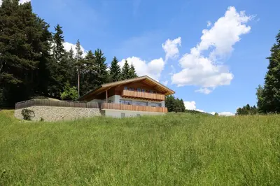 a house on top of a grassy hill at Haus Waldruhe in Villandro