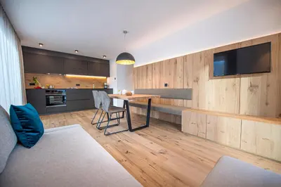 a living room with a table and a kitchen at apartment allium in Selva di Val Gardena