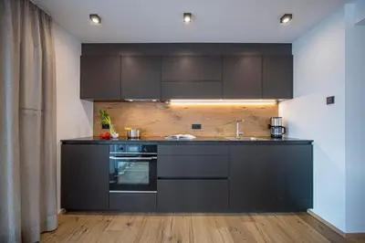 a kitchen with black cabinets and a sink at apartment allium in Selva di Val Gardena