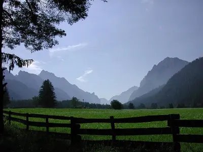 a fence in a field with mountains in the background at B&B Villa Dolomites Hut in San Vigilio Di Marebbe