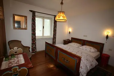 a bedroom with a bed and a table and a window at B&B Villa Dolomites Hut in San Vigilio Di Marebbe
