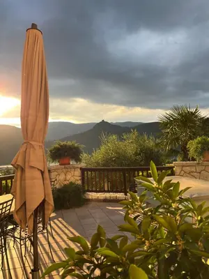 aige umbrella sitting on a patio with mountains in the background at Leuchtenhof in Caldaro