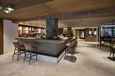 a bar in a restaurant with chairs and tables at Berghotel in Racines